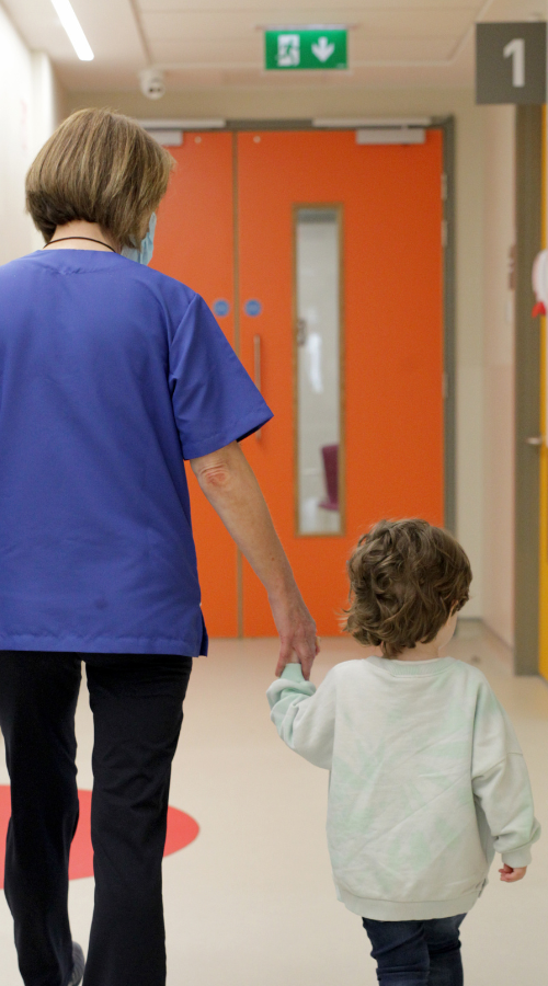 Nurse and child holding hands